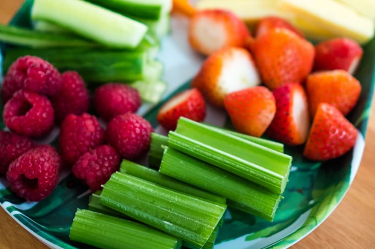 plate of raspberries, celery and strawberries